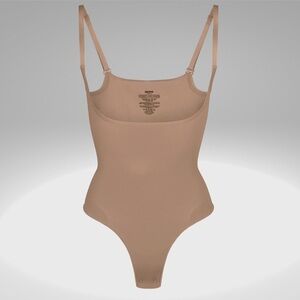 NTW Skims Seamless Sculpt Open Bust Thong Bodysuit in the Sienna color.